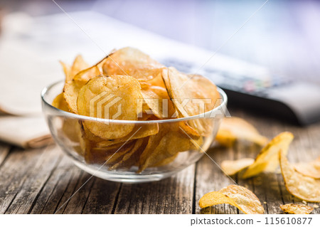 Crispy Potato Chips in bowl on wooden table. 115610877