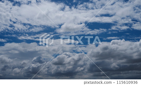 A blue sky with white clouds is adorned with a brilliant shade of blue, adorned with puffy, fluffy white clouds. 115610936