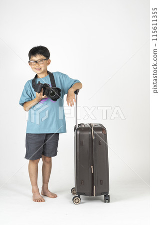 "Summer travel image" of an elementary school boy wearing summer clothes and carrying a suitcase and a camera 115611355