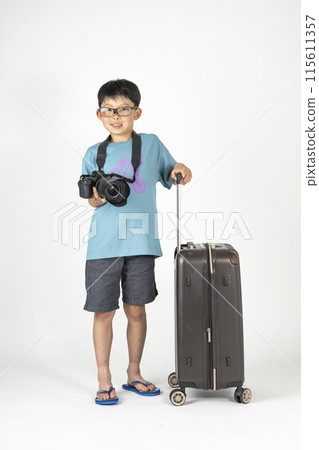 "Summer travel image" of an elementary school boy wearing summer clothes and carrying a suitcase and a camera 115611357