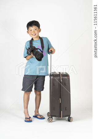 "Summer travel image" of an elementary school boy wearing summer clothes and carrying a suitcase and a camera 115611361