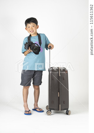 "Summer travel image" of an elementary school boy wearing summer clothes and carrying a suitcase and a camera 115611362