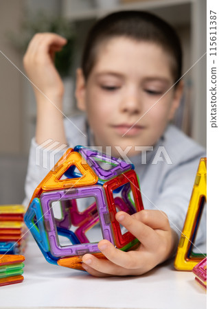 A child plays with a magnetic construction set. Interesting educational toys. 115611387
