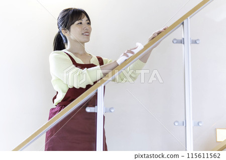 A woman in an apron wiping clean A woman in an apron wiping clean 115611562