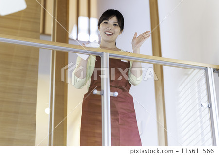 A woman in an apron wiping clean 115611566