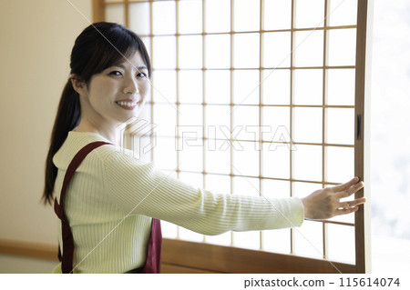 一位中年婦女在日式房間打開障子 一位中年婦女在日式房間打開障子 115614074