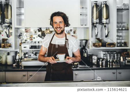 Handsome barista working in coffee shop, preparing coffee. University student working part-time in cafe. Handsome barista working in coffee shop, preparing coffee. University student working part-time in cafe. 115614621