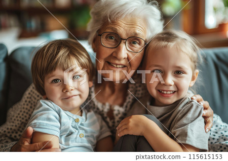 Joyful grandmother embracing her grandchildren with love and happiness in a cozy, warm home, creating a strong multigenerational familial bond and nurturing relationship 115615153