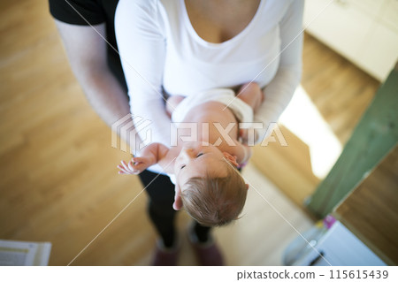 New parents holding newborn baby girl. Unconditional paternal love, idyllic family moment. 115615439