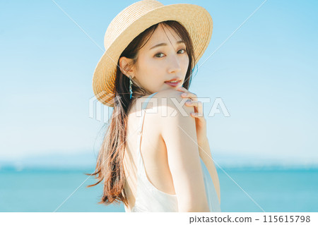 戴著草帽的女人，背景是海和藍天 115615798