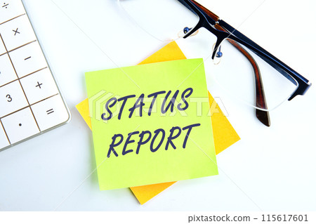 Inscription Status Report text the inscription on the sticker on a light background next to the clock and calculator Inscription Status Report text the inscription on the sticker on a light background next to the clock and calculator 115617601
