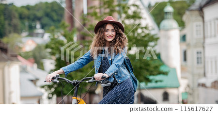 Female traveller on electric scooter in small city, sightseeing. Young tourist using bike during her summer solo trip, vacation. Banner with copy space. Female traveller on electric scooter in small city, sightseeing. Young tourist using bike during her summer solo trip, vacation. Banner with copy space. 115617627