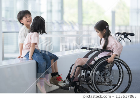An elementary school student in a wheelchair and a friend talking at eye level - an image of a barrier-free mind An elementary school student in a wheelchair and a friend talking at eye level - an image of a barrier-free mind 115617863