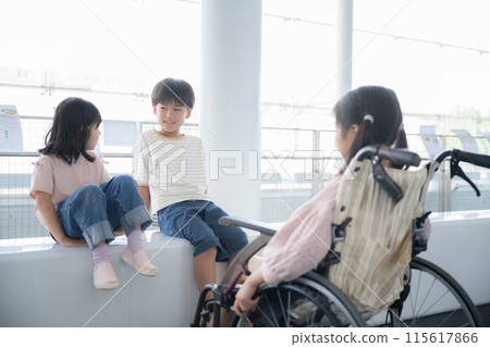An elementary school student in a wheelchair and a friend talking at eye level - an image of a barrier-free mind An elementary school student in a wheelchair and a friend talking at eye level - an image of a barrier-free mind 115617866