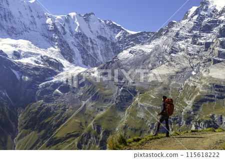 Sporty woman standing in front of snow mountains and enjoying view of Switzerland nature. Wanderlust, sport, beauty in nature. 115618222