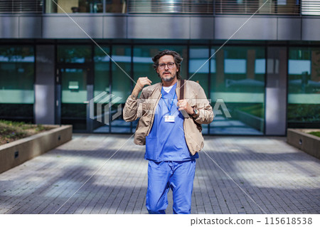 Doctor in uniform going home from work, looking at camera. Work-life balance of healthcare worker. Doctor in uniform going home from work, looking at camera. Work-life balance of healthcare worker. 115618538