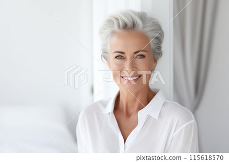 Portrait of beautiful happy smiling mature woman with gray hair in white living room at home 115618570