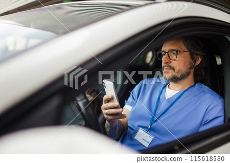 Doctor getting into car, going home from work, texting. Work-life balance of healthcare worker. Doctor getting into car, going home from work, texting. Work-life balance of healthcare worker. 115618580