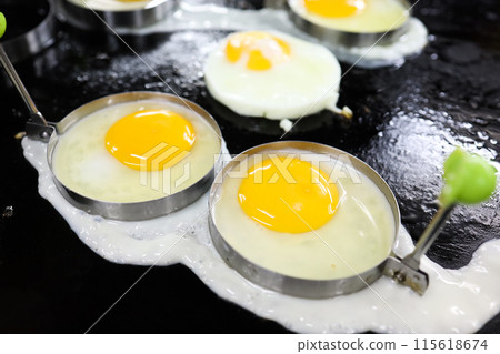 Top view of Fried egg in stainless steel mood ring on hot pan, focus selective 115618674