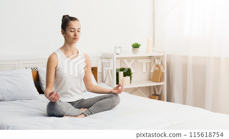 Morning Meditation. Woman Practising Yoga In The Morning, Sitting On Bed, Free Space Morning Meditation. Woman Practising Yoga In The Morning, Sitting On Bed, Free Space 115618754