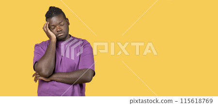 Tired young african american man sleeping leaning on his hands after overworking standing on yellow studio background. Bored millennial guy napping feeling sleepy, suffering from insomnia 115618769