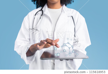 Young black woman doctor therapist in white coat uses tablet with blank screen and molecules, isolated on blue studio background, collage. App for medical, health care, science website Young black woman doctor therapist in white coat uses tablet with blank screen and molecules, isolated on blue studio background, collage. App for medical, health care, science website 115618953