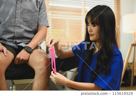 Physical therapist placing kinesio tape on patient knee. Physical therapy and rehabilitation concept 115619329
