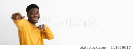 Funny charismatic handsome african american millennial guy in yellow sweater gesturing while posing on white studio background and smiling, pointing with index fingers, copy space Funny charismatic handsome african american millennial guy in yellow sweater gesturing while posing on white studio background and smiling, pointing with index fingers, copy space 115619617