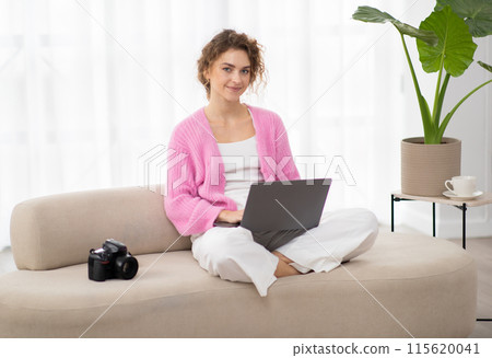 Portrait Of Smiling Young Woman With Laptop Sitting On Couch Next To Photocamera, Beautiful Millennial Freelance Photographer Lady Using Computer At Home For Editing Photos, Copy Space Portrait Of Smiling Young Woman With Laptop Sitting On Couch Next To Photocamera, Beautiful Millennial Freelance Photographer Lady Using Computer At Home For Editing Photos, Copy Space 115620041