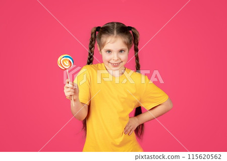 Little Sweet Tooth. Cute preteen girl smiling and holding colorful lollipop, cheerful happy female child with candy in hand looking at camera, posing isolated over pink studio background, copy space Little Sweet Tooth. Cute preteen girl smiling and holding colorful lollipop, cheerful happy female child with candy in hand looking at camera, posing isolated over pink studio background, copy space 115620562