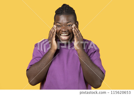 LOL. Black Man Laughing Out Loud Touching Face Looking At Camera Standing Over Yellow Studio Background, Wearing Casual Purple T-Shirt. Positive Emotions, Laughter Concept LOL. Black Man Laughing Out Loud Touching Face Looking At Camera Standing Over Yellow Studio Background, Wearing Casual Purple T-Shirt. Positive Emotions, Laughter Concept 115620653