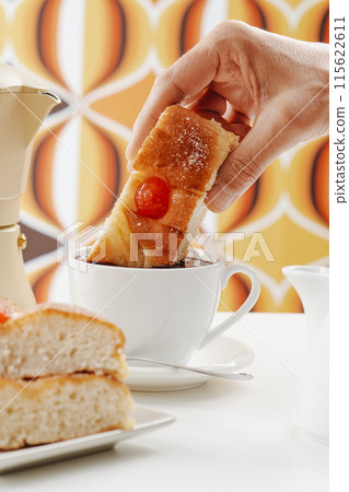 man dips coca de sant joan in hot chocolate 115622611
