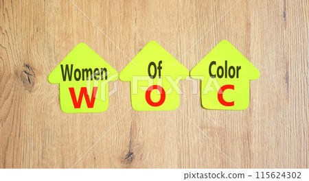 WOC women of color symbol. Concept words WOC women of color on beautiful yellow paper. Beautiful wooden background. Business WOC women of color social issues concept. Copy space. 115624302