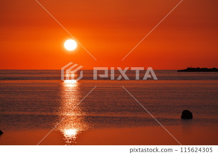 Watching the sun rise over the calm sea in early spring from the northernmost point of Japan 115624305