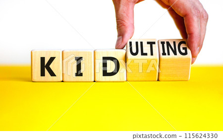 Kid or kidulting symbol. Concept words Kid or Kidulting on wooden cubes. Beautiful yellow table white background. Psychologist hand. Healthy lifestyle and kid or kidulting concept. Copy space. 115624330