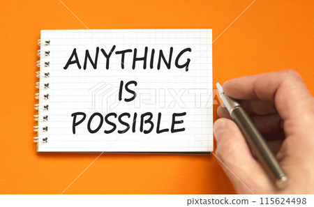 Anything is possible symbol. Concept words Anything is possible on beautiful white note. Beautiful orange background. Businessman hand. Business anything possible concept. Copy space. 115624498