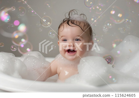 Adorable baby with expressive eyes smiling during a bubble bath 115624605