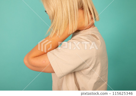 A woman is holding her neck and she is in pain 115625346
