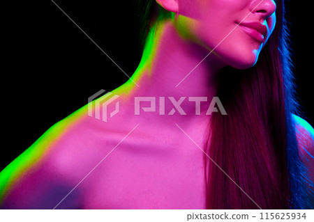 Cropped image of young girl, shoulders and long hair against black studio background in neon light 115625934