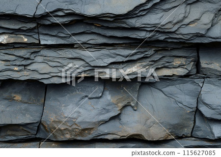 Close up of rugged and durable textured slate rock layers, stratified and natural, forming a detailed and abstract geological pattern Close up of rugged and durable textured slate rock layers, stratified and natural, forming a detailed and abstract geological pattern 115627085