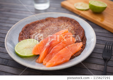 Salted salmon fillet with buckwheat pancakes and lime Salted salmon fillet with buckwheat pancakes and lime 115627291