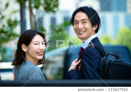 Businessman and businesswoman walking in the office town Businessman and businesswoman walking in the office town 115627502