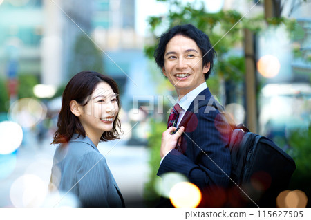 Businessman and businesswoman walking in the office town Businessman and businesswoman walking in the office town 115627505
