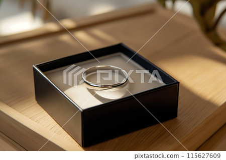 Sunlight casting a warm glow on a simple yet sophisticated wedding ring presented in a stylish box Sunlight casting a warm glow on a simple yet sophisticated wedding ring presented in a stylish box 115627609