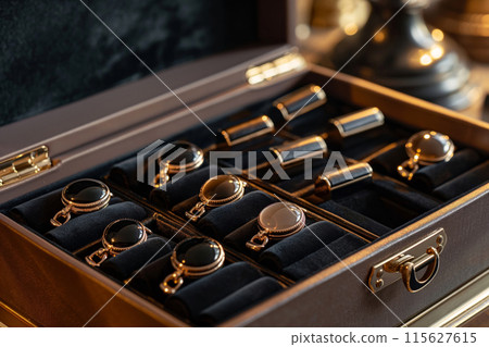 Close-up view of a sophisticated box showcasing a luxury watch set with a warm ambiance 115627615