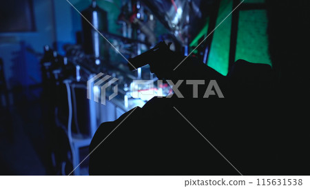 Man with a handgun inspects an illegal laboratory during a night police raid, part of an investigation Man with a handgun inspects an illegal laboratory during a night police raid, part of an investigation 115631538