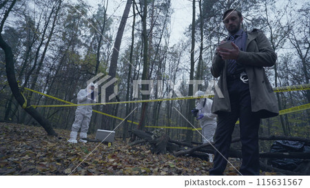 Forensic experts collecting evidence, police investigator writing down case details Forensic experts collecting evidence, police investigator writing down case details 115631567