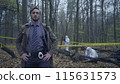 Professional police detective standing near a crime scene with hands akimbo 115631573