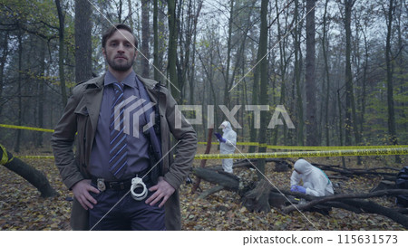 Professional police detective standing near a crime scene with hands akimbo Professional police detective standing near a crime scene with hands akimbo 115631573