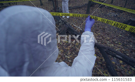 Forensic experts in uniform examining a forest hazard area, conducting an investigation 115631583